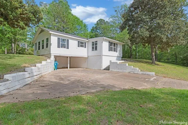 a view of a yard in front of a house with large trees