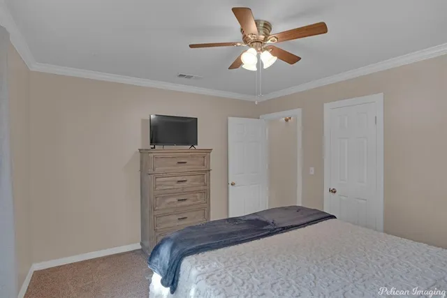 a bedroom with a bed and a flat tv screen on dresser