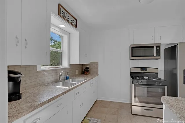 a kitchen with appliances a sink and cabinets