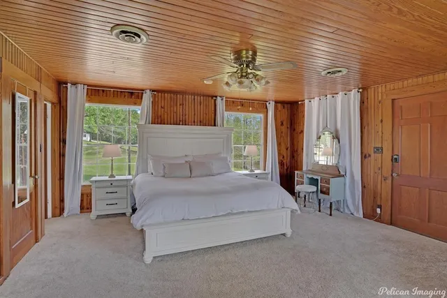 a spacious bedroom with a large bed and a chandelier