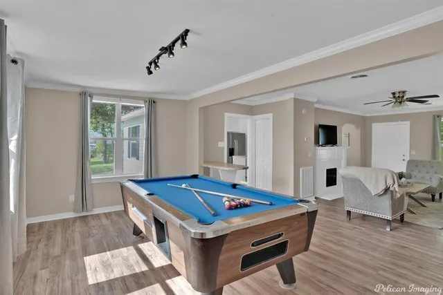 a room with pool table and wooden floor