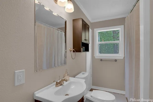 a bathroom with a toilet a sink and mirror