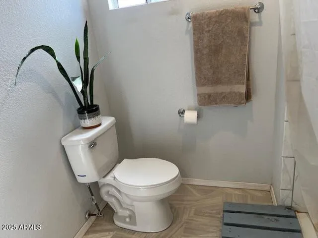 a white toilet sitting next to a shower