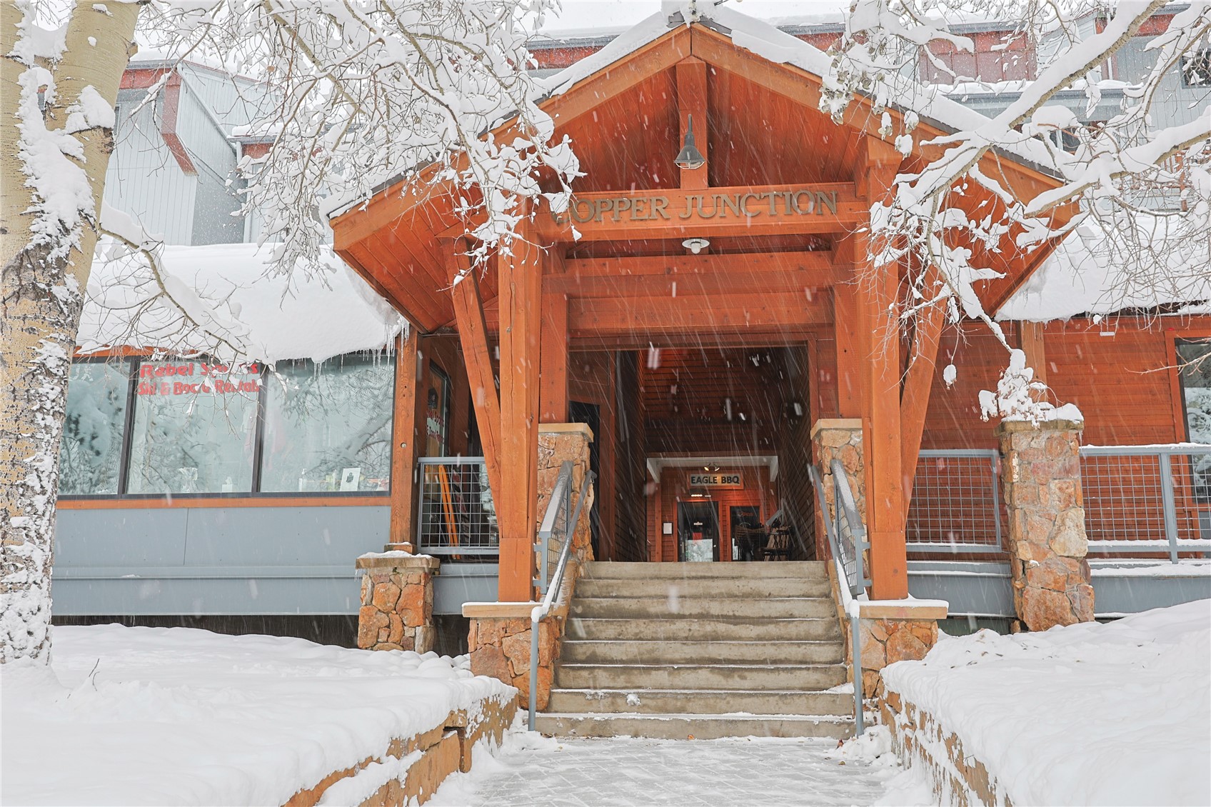 Snow covered property entrance featuring covered porch