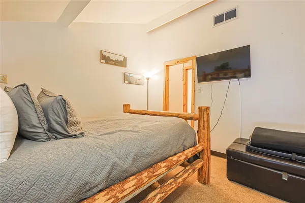 a bedroom with a bed and flat screen tv