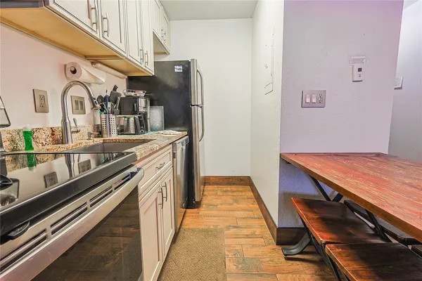 a hallway with stainless steel appliances granite countertop a stove and cabinets