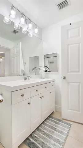 a spacious bathroom with a double vanity sink and a mirror