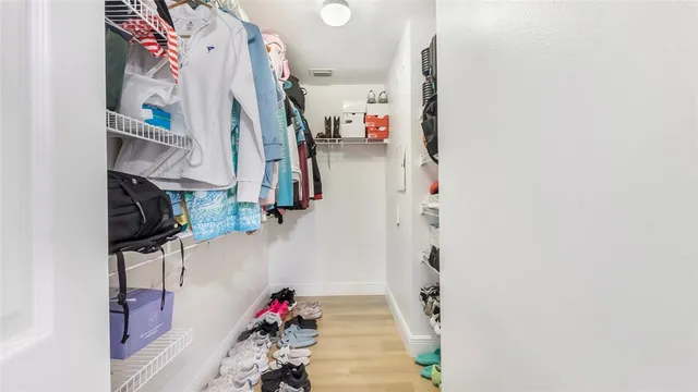 a view of walk in closet with clothes and shoes