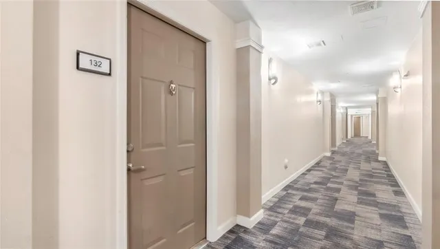 a view of a hallway with a door and stairs