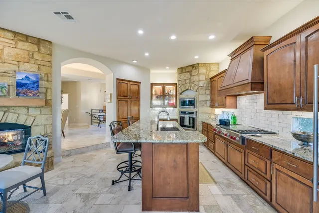 a kitchen with granite countertop cabinets a sink and a stove