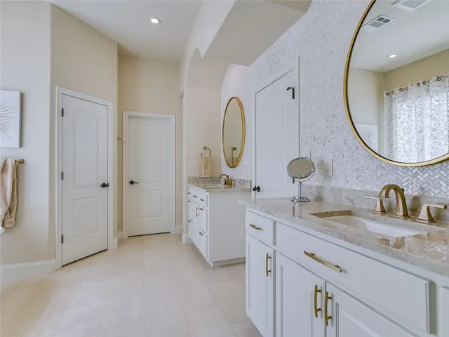 a spacious bathroom with a double vanity sink and a mirror