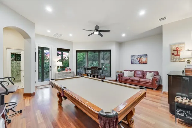 a living room with stainless steel appliances furniture a rug and a large window