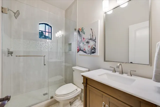 a bathroom with a granite countertop sink a toilet and shower