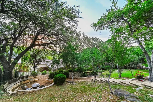 a view of a backyard with table and chairs and a barbeque