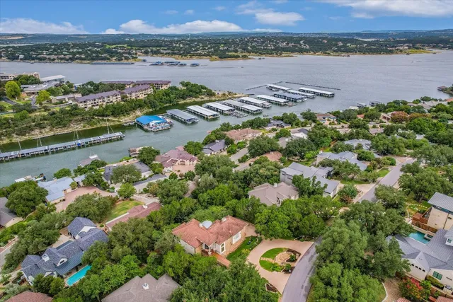 an aerial view of ocean and residential houses with outdoor space