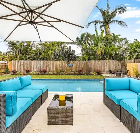 a view of swimming pool with a couches in a patio