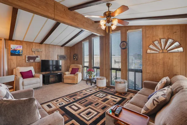 a living room with furniture a chandelier and a flat screen tv