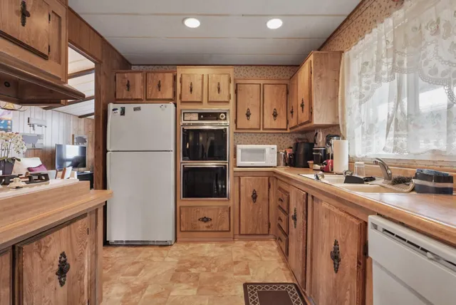 a kitchen with stainless steel appliances granite countertop a refrigerator a stove a sink and a microwave