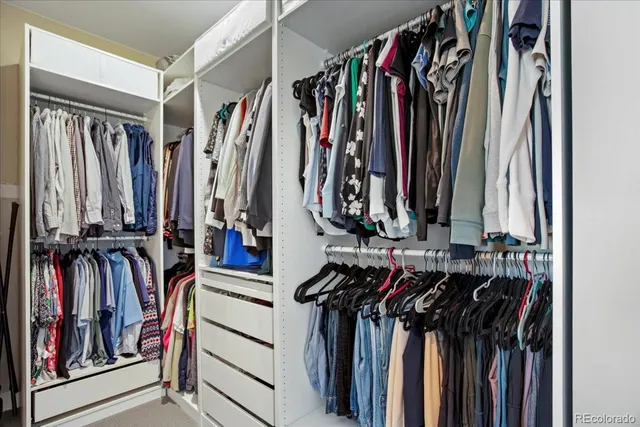 a view of walk in closet with clothes