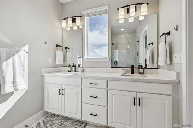 a bathroom with double vanity sinks and a mirror