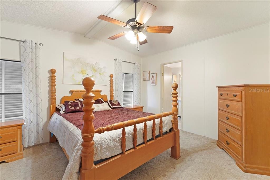 8308 Princess Court Palmetto, FL 34221 - Photo 13 of 23 a bedroom with furniture and a chandelier