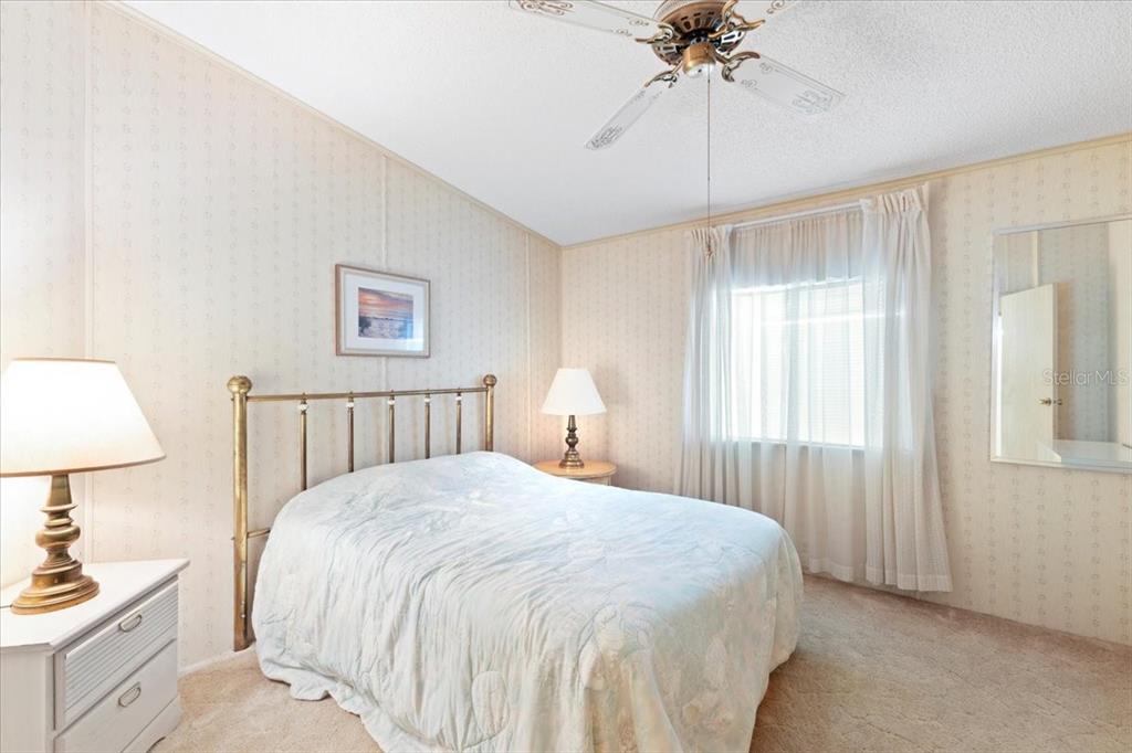 8308 Princess Court Palmetto, FL 34221 - Photo 16 of 23 a bedroom with a bed and a chandelier
