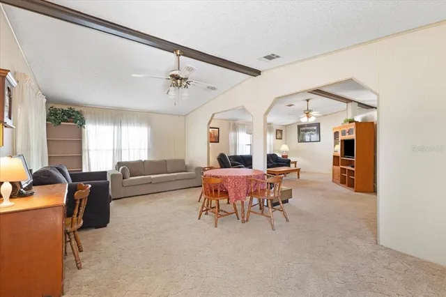 a living room with furniture a chandelier and a window