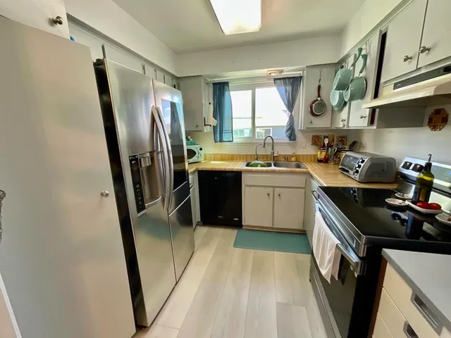 a kitchen with stainless steel appliances a sink stove and refrigerator