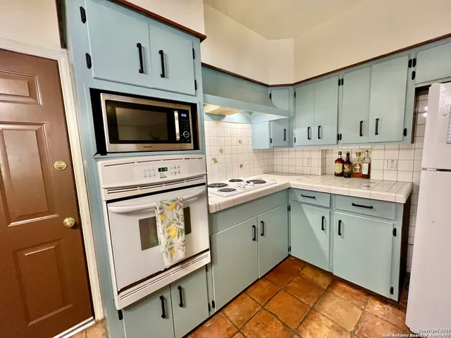 a kitchen with cabinets stainless steel appliances and a sink