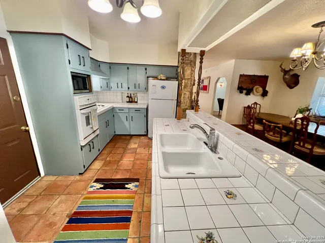 a room with white cabinets and washer dryer