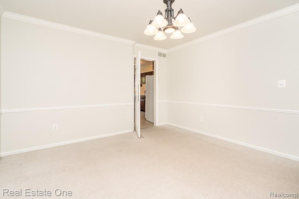 2355 Hillendale Drive Rochester, MI 48309 - Photo 13 of 44 Carpeted room featuring a ceiling-mounted light fixture, crown molding, and wainscoting