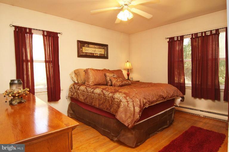245 Stem Road Union Bridge, MD 21791 - Photo 17 of 26 a spacious bedroom with a bed and a chandelier