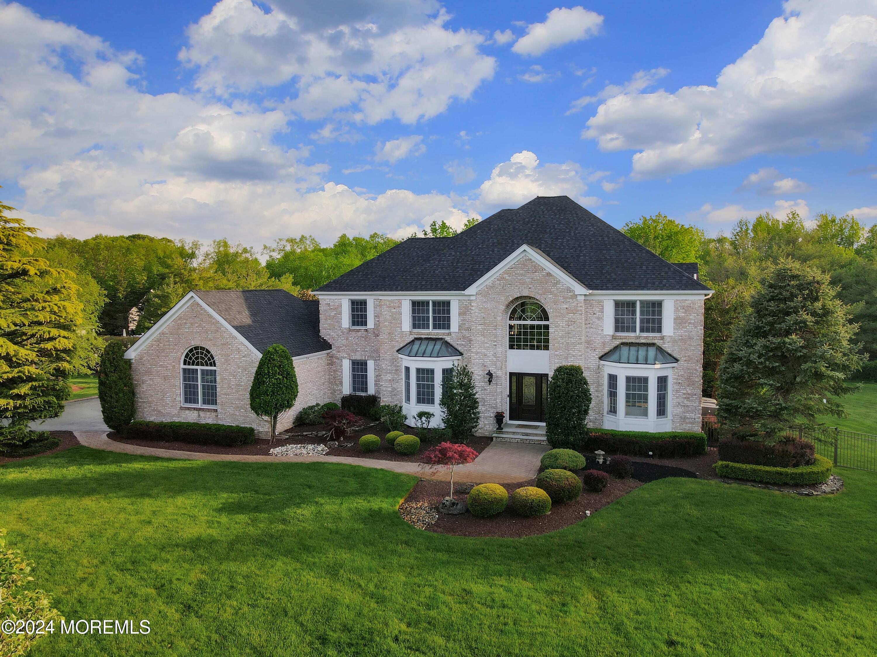 12 Shadowbrook Drive Colts Neck, NJ 07722 - Photo 2 of 33 a front view of a house with a garden and trees