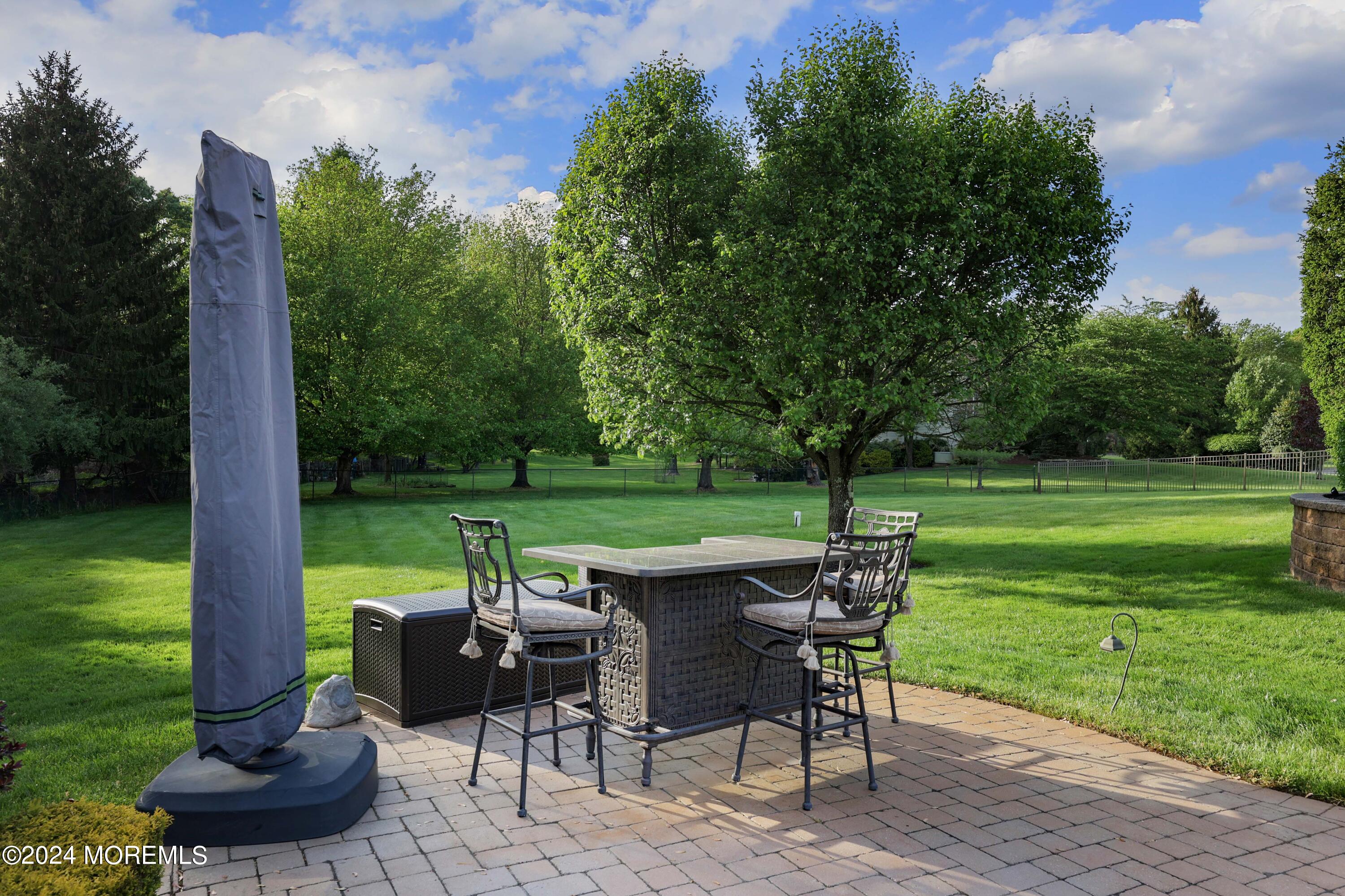 12 Shadowbrook Drive Colts Neck, NJ 07722 - Photo 27 of 33 a view of a table and chairs in patio with a yard