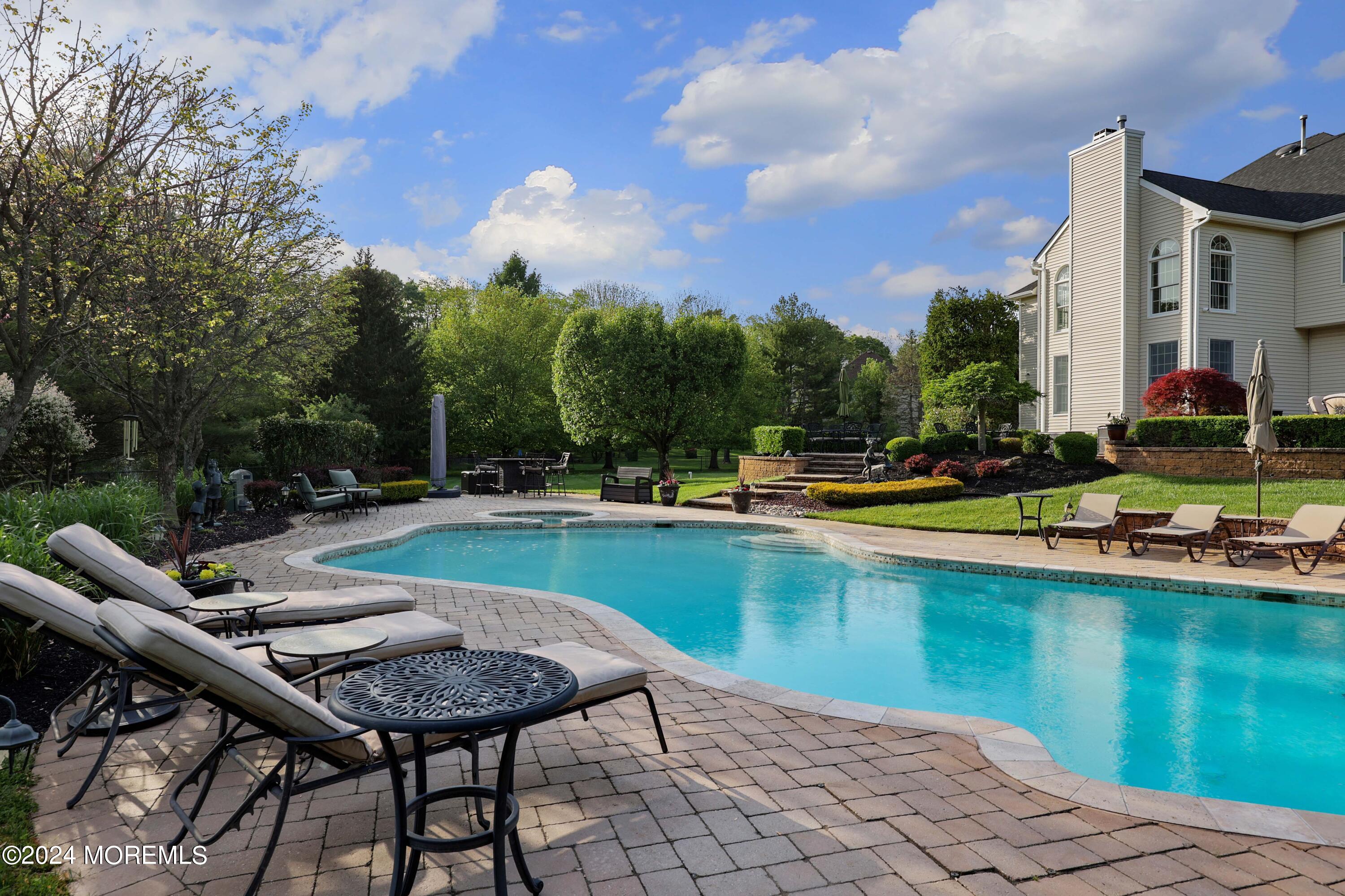 12 Shadowbrook Drive Colts Neck, NJ 07722 - Photo 28 of 33 a view of swimming pool with outdoor seating and lake