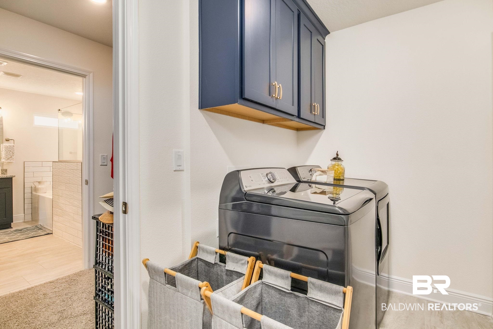 2222 Club House Drive Lillian, AL 36549 - Photo 17 of 49 Laundry room featuring cabinet space, washer and dryer, and light carpet