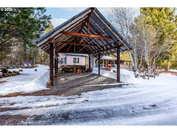 a view of a house with a yard covered in snow