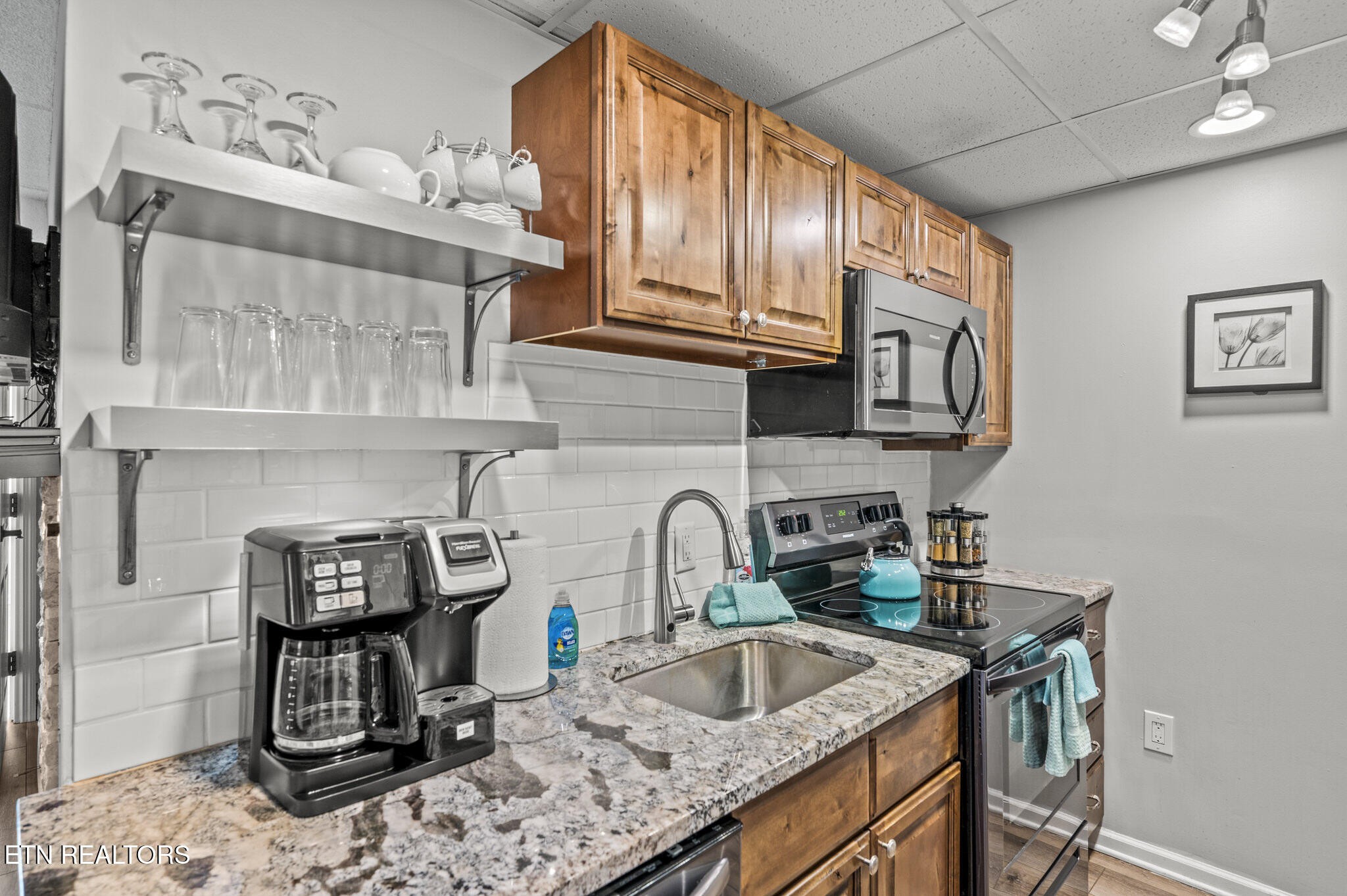 413 Baskins Creek Road, Unit 406 Gatlinburg, TN 37738 - Photo 11 of 26 a kitchen with stainless steel appliances granite countertop a sink stove and cabinets