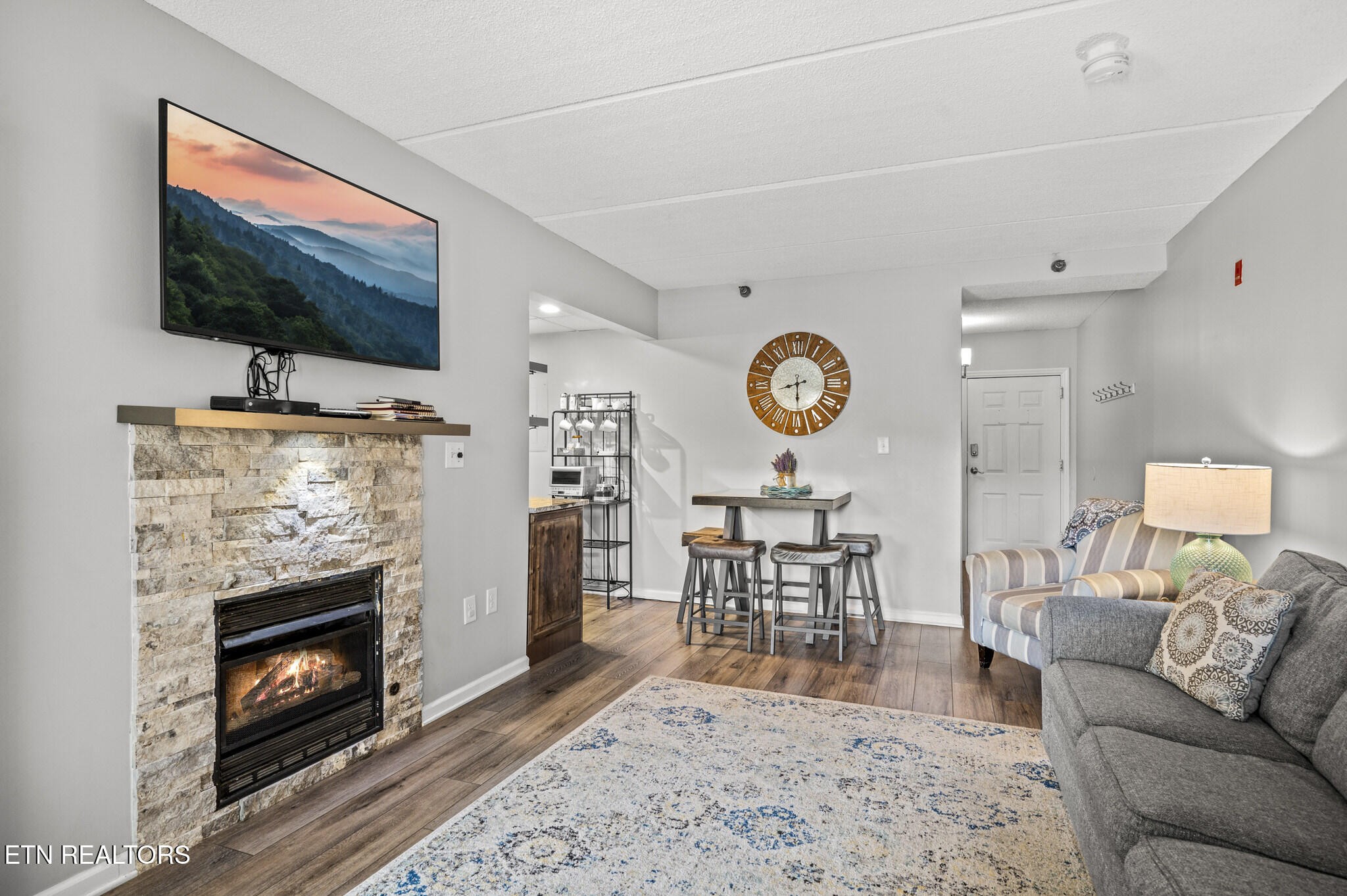 413 Baskins Creek Road, Unit 406 Gatlinburg, TN 37738 - Photo 3 of 26 a living room with furniture a flat screen tv and a fireplace