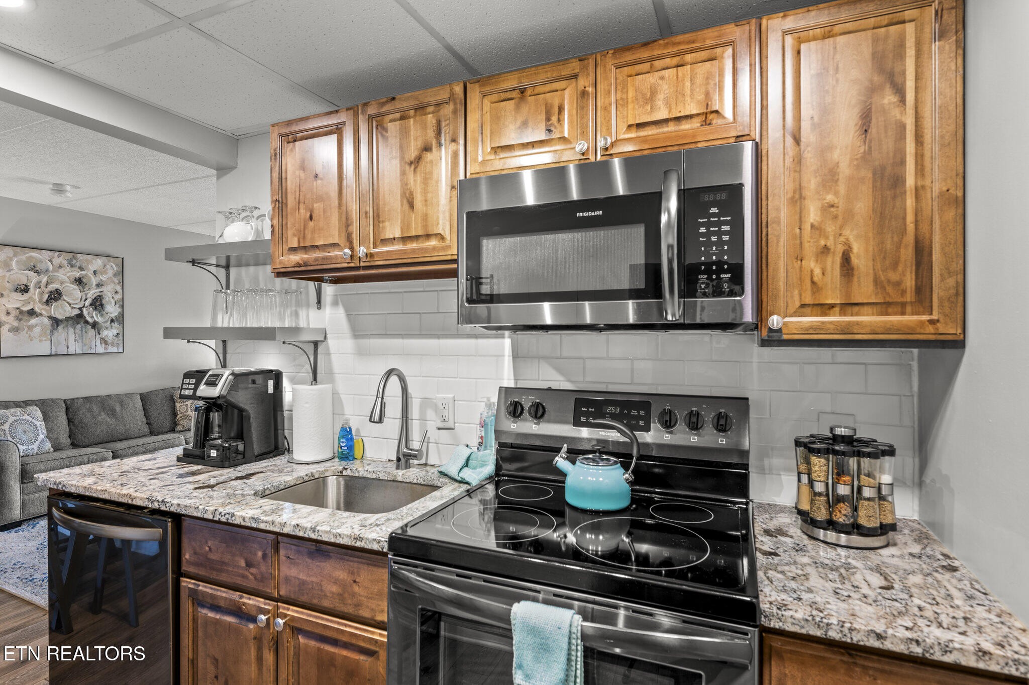 413 Baskins Creek Road, Unit 406 Gatlinburg, TN 37738 - Photo 10 of 26 a kitchen with stainless steel appliances granite countertop a stove a sink and a microwave
