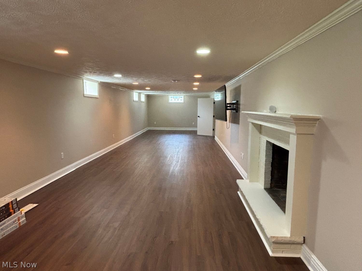 11861 Summers Road Chesterland, OH 44026 - Photo 19 of 30 Huge recreation room with crown molding, fireplace, recessed lighting and LVT flooring