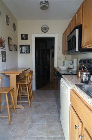 48 Strathmore Road, Unit 26 Boston, MA 02135 - Photo 7 of 10 a kitchen with stainless steel appliances granite countertop a stove a sink and a microwave