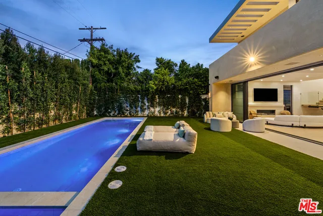 a swimming pool with outdoor seating and yard