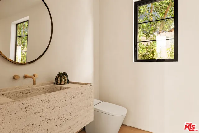 a bathroom with a toilet sink and mirror