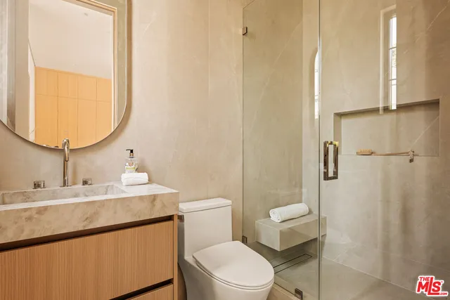 a bathroom with a toilet a sink and a mirror