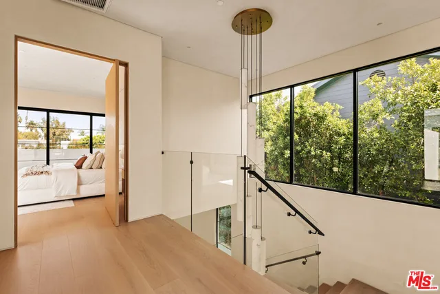 a large white bed sitting in a bedroom next to a window