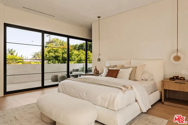 a bedroom with a large bed and a flat tv screen on dresser