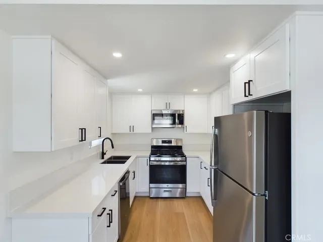 a kitchen with stainless steel appliances a refrigerator sink and stove