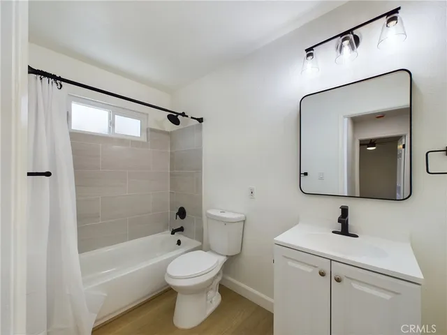 a bathroom with a toilet a sink a mirror a bathtub and shower