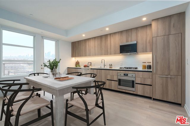 a kitchen with a table chairs refrigerator and microwave
